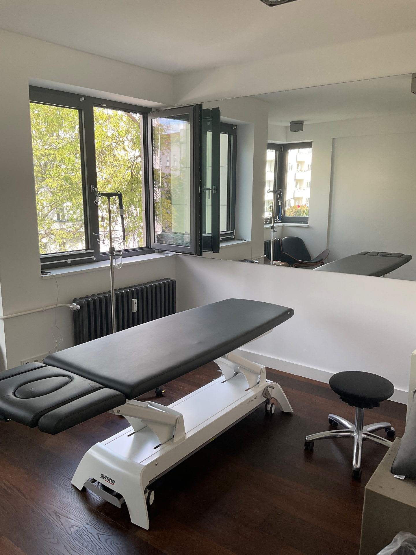 Behandlungsraum mit Behandlungsliege am Fenster im Standort Kantstraße