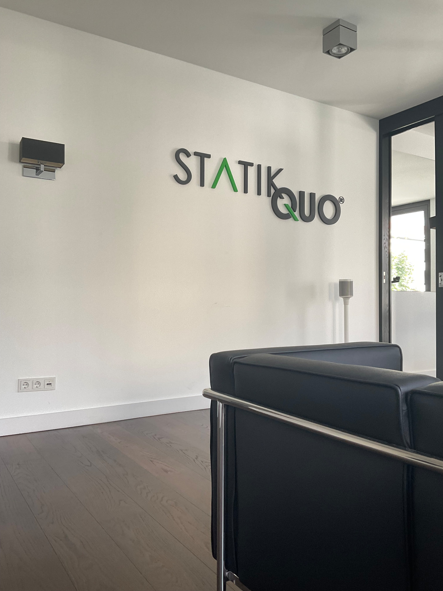 Empfangsbereich mit StatikQuo-Logo an der Wand im Standort Kantstraße